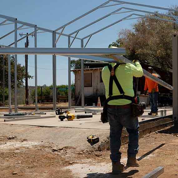 Installer carrying carport materials